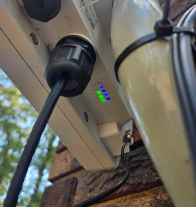 Underside of a mounted Titan 4000 with its cable gland sealed and status lights glowing blue and green